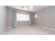 Neutral bedroom with large window, modern ceiling fan, and neutral carpeting at 12547 W Stella Ln, Litchfield Park, AZ 85340