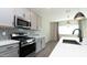 Modern kitchen with stainless steel appliances, gray cabinets, and sleek countertops at 12547 W Stella Ln, Litchfield Park, AZ 85340