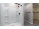 Walk-in shower with white tile surround and a large shower head at 12547 W Stella Ln, Litchfield Park, AZ 85340