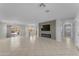 Bright, open living room featuring tile flooring, a modern fireplace, and seamless access to outdoor spaces at 12630 W Corrine Dr, El Mirage, AZ 85335
