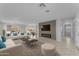 Modern living room with tile floors, stylish fireplace, and an open layout to the dining area at 12630 W Corrine Dr, El Mirage, AZ 85335