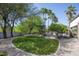 Well-manicured backyard with a circular lawn, mature trees, rock features, and a decorative gravel border at 12820 N 83Rd Pl, Scottsdale, AZ 85260