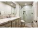 Bright bathroom with a granite countertop vanity, tile flooring, and a glass enclosed shower at 12820 N 83Rd Pl, Scottsdale, AZ 85260