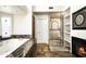 Bright bathroom featuring a marble-surround tub, glass shower, built-in shelving, and a fireplace at 12820 N 83Rd Pl, Scottsdale, AZ 85260