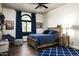 This bedroom features a wooden bed frame, stylish blue bedding, and a unique arched window for natural light at 12820 N 83Rd Pl, Scottsdale, AZ 85260