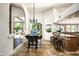 Open-concept dining area with a modern chandelier, bar seating, and seamless access to outdoor scenery at 12820 N 83Rd Pl, Scottsdale, AZ 85260