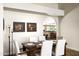 Bright dining room featuring a wood table, upholstered chairs, and modern light fixture at 12820 N 83Rd Pl, Scottsdale, AZ 85260