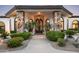 Inviting front entrance with stone pillars, arched windows, and meticulously manicured landscaping at 12820 N 83Rd Pl, Scottsdale, AZ 85260