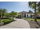 Stunning single-story home featuring arched windows, stone accents, and a circular driveway surrounded by palm trees at 12820 N 83Rd Pl, Scottsdale, AZ 85260