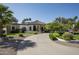 Captivating single-story home with stone accents, arched windows, and a circular driveway surrounded by mature trees at 12820 N 83Rd Pl, Scottsdale, AZ 85260