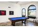 Bright game room featuring a billiard table, travertine floors, and arched windows at 12820 N 83Rd Pl, Scottsdale, AZ 85260