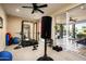 Home gym equipped with weight rack, punching bag, and access to the backyard patio and pool at 12820 N 83Rd Pl, Scottsdale, AZ 85260