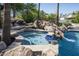 Custom hot tub with stone accents and waterfall feature, seamlessly integrated with the inviting pool area at 12820 N 83Rd Pl, Scottsdale, AZ 85260
