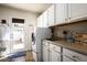 Well-organized laundry room with white cabinets, modern washer/dryer, sink, and access to the outdoor patio at 12820 N 83Rd Pl, Scottsdale, AZ 85260