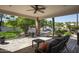 Cozy covered patio area with stone columns and serene views of the lush backyard with waterfall feature at 12820 N 83Rd Pl, Scottsdale, AZ 85260
