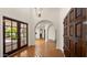 Wide foyer with red tile flooring, arched doorways, wood doors, and natural light at 13007 N 1St St, Phoenix, AZ 85022