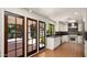 Modern kitchen featuring white cabinetry, stainless steel appliances, custom tile backsplash, and terra-cotta tile flooring at 13007 N 1St St, Phoenix, AZ 85022