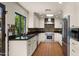 Well-lit kitchen with white cabinets, black countertops, colorful backsplash, stainless appliances and Saltillo tile floors at 13007 N 1St St, Phoenix, AZ 85022