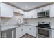 Bright kitchen features white cabinets, stainless steel appliances, and granite countertops at 1325 W 7Th Ave, Mesa, AZ 85202