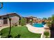 Expansive backyard showcases a pool, artificial turf, and a cozy covered patio for outdoor living at 13561 W Montebello Ave, Litchfield Park, AZ 85340