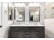 Bathroom featuring double sinks with marble countertops and modern lighting fixtures at 13561 W Montebello Ave, Litchfield Park, AZ 85340