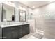 Spa-like bathroom with double vanity, marble countertops, and a frameless glass shower with tile accents at 13561 W Montebello Ave, Litchfield Park, AZ 85340