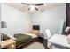 Comfortable bedroom with dark wood floors, light blue walls, ceiling fan, and a study desk at 13561 W Montebello Ave, Litchfield Park, AZ 85340