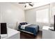 Bright bedroom featuring a ceiling fan, white trim, and a large window offering natural light at 13561 W Montebello Ave, Litchfield Park, AZ 85340