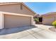 Spacious three-car garage with extended driveway, desert landscaping, and neutral color scheme at 13561 W Montebello Ave, Litchfield Park, AZ 85340
