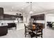 Modern kitchen with stainless steel appliances, an island, and a dining area with a wooden table at 13561 W Montebello Ave, Litchfield Park, AZ 85340