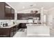 Modern kitchen with stainless steel appliances, granite countertops, and dark wood cabinetry at 13561 W Montebello Ave, Litchfield Park, AZ 85340