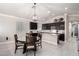 Open kitchen with dark cabinets, granite countertops, stainless steel appliances, and a dining area at 13561 W Montebello Ave, Litchfield Park, AZ 85340