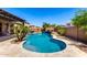 Beautiful backyard pool with a rock waterfall feature and lush landscaping, ideal for relaxation at 13561 W Montebello Ave, Litchfield Park, AZ 85340