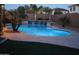 Evening shot of backyard pool with waterfall, landscaping, and ambient lighting for a relaxing atmosphere at 13561 W Montebello Ave, Litchfield Park, AZ 85340