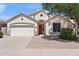 Charming single-story home with a two car garage, red door, desert landscaping and neutral colored stucco at 146 E Rock Wren Dr, San Tan Valley, AZ 85143