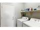 Functional laundry room with washer, dryer, and storage shelves at 146 E Rock Wren Dr, San Tan Valley, AZ 85143