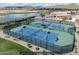 Aerial view of tennis courts with lake and mountain views beyond enhance community living at 146 E Rock Wren Dr, San Tan Valley, AZ 85143