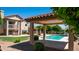 Charming backyard featuring a covered patio, pool, lush lawn, and mature trees for ultimate outdoor living at 1532 N Ogden --, Mesa, AZ 85205