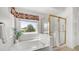 Bright bathroom featuring a tub under a window and a glass enclosed shower at 1532 N Ogden --, Mesa, AZ 85205