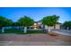 Charming home with mature citrus trees lining the driveway, a manicured lawn, and a well-lit facade at 1532 N Ogden --, Mesa, AZ 85205