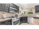 Granite counters and black cabinets adorn this kitchen with stainless steel appliances and tile backsplash at 1532 N Ogden --, Mesa, AZ 85205