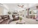 Living room with a leather sectional couch, a ceiling fan and a view to the kitchen and dining area at 1532 N Ogden --, Mesa, AZ 85205