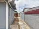 A functional side yard featuring privacy walls, storage shed, and gravel, with convenient access at 1553 E Flower Cir, Mesa, AZ 85204
