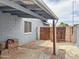 Backyard showing the covered patio, wooden gate, privacy walls, brick details and gravel ground at 1553 E Flower Cir, Mesa, AZ 85204