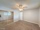 Spacious bedroom featuring carpet flooring and a closet with mirrored doors at 1553 E Flower Cir, Mesa, AZ 85204