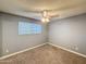 This bedroom features neutral tones, a ceiling fan and a window with horizontal blinds at 1553 E Flower Cir, Mesa, AZ 85204