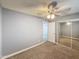 Neutral bedroom featuring plush carpet, ceiling fan, and mirrored closet doors at 1553 E Flower Cir, Mesa, AZ 85204