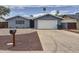 Charming single-story home featuring a two-car garage, well-maintained yard, and desert landscaping at 1553 E Flower Cir, Mesa, AZ 85204