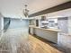 Modern, open kitchen and living space with island cooktop and updated lighting fixtures at 1553 E Flower Cir, Mesa, AZ 85204