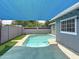 Backyard pool under shade sail features privacy walls, turf, and access to the rear of the house at 1553 E Flower Cir, Mesa, AZ 85204